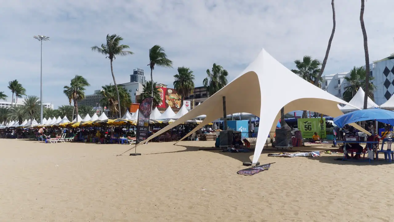 Beachgoers sitting and lazing in the sun at the beachfront in Pattaya located in Chonburi province on the east side of Thailand