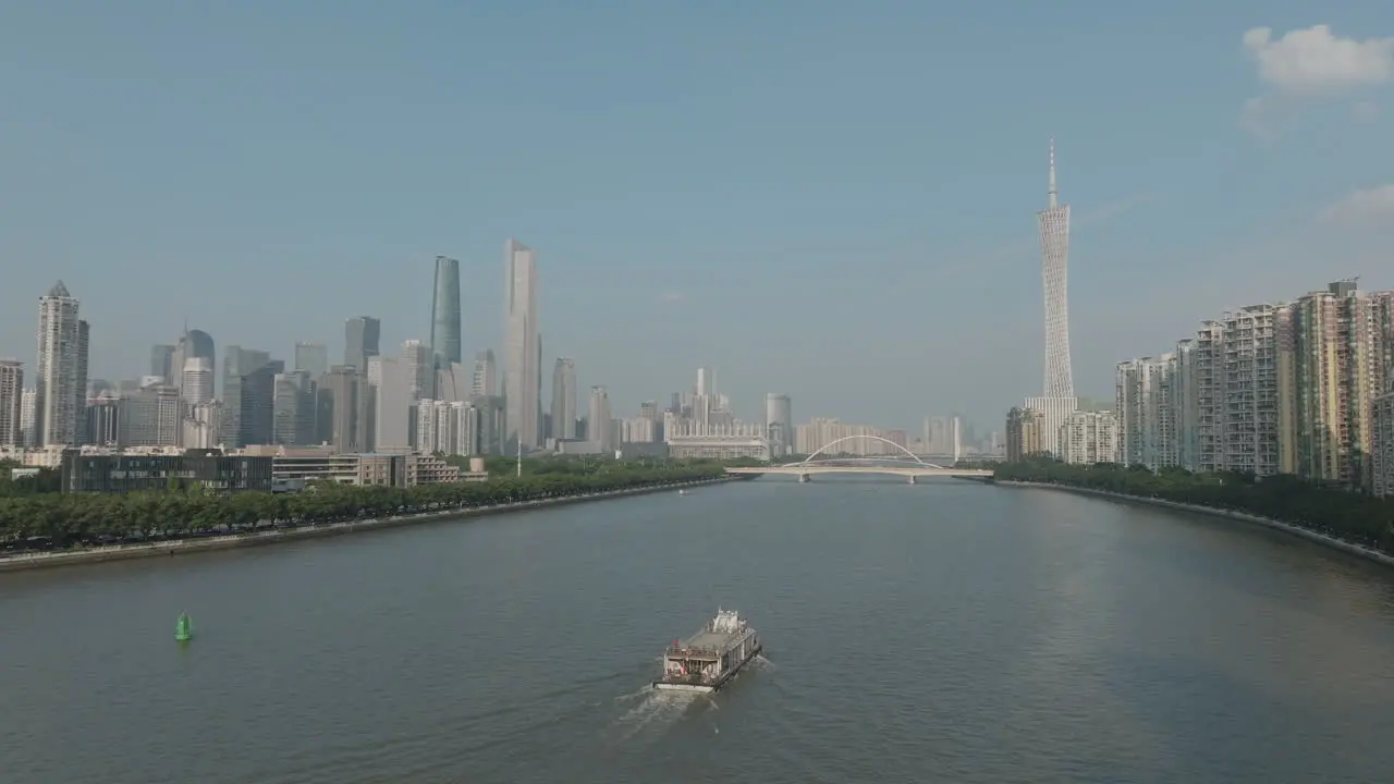 Aerial rising shot focusing on a ferry boat on the river in downtown Guangzhou city China