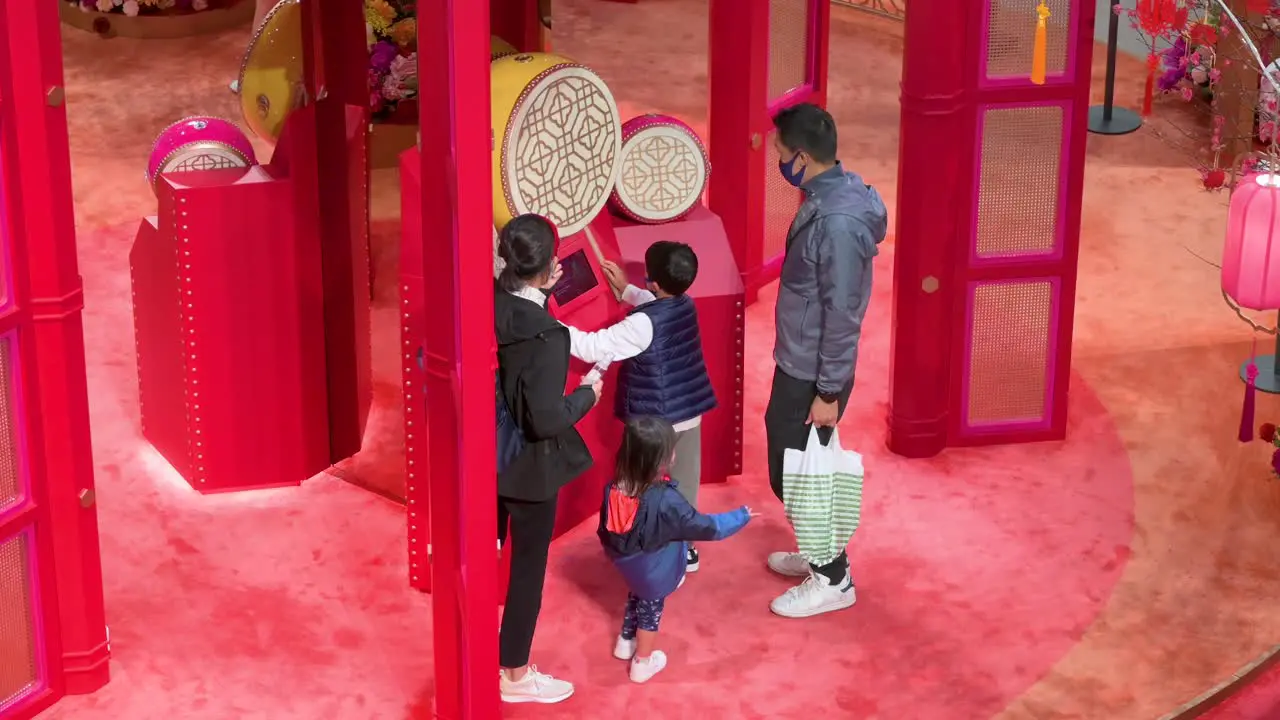 A boy plays a traditional drum as a family visit a Chinese New Year theme installation event for the Chinese Lunar New Year in Hong Kong