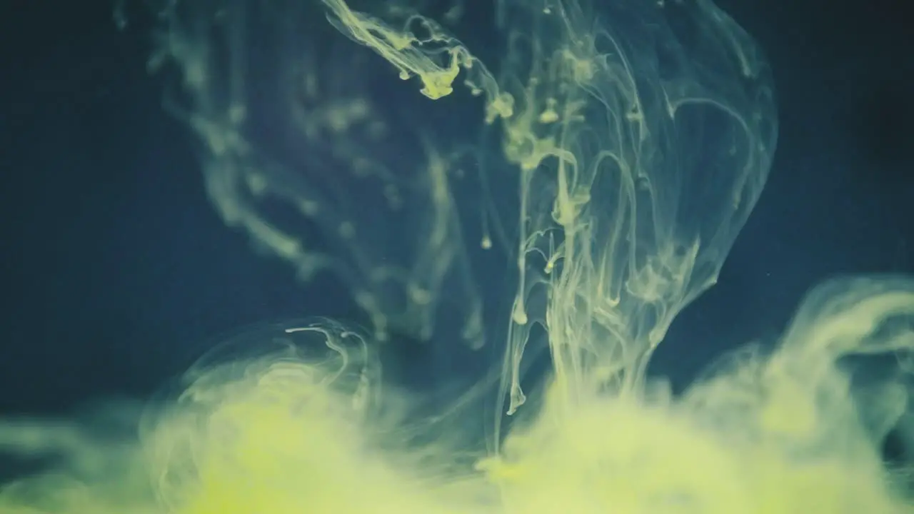 Green ink lingering in water in slow motion