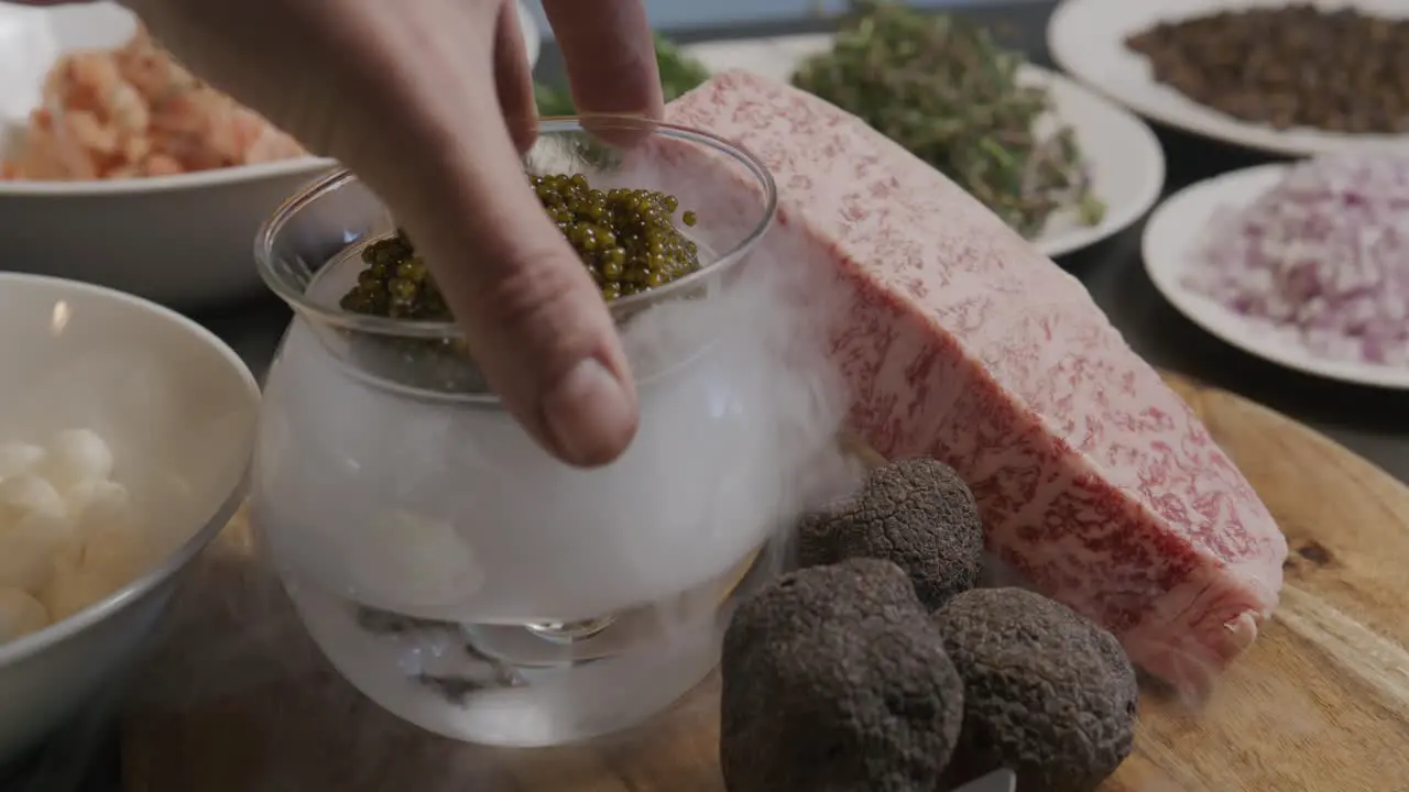 Caviar being placed into dry ice to create a visual effect