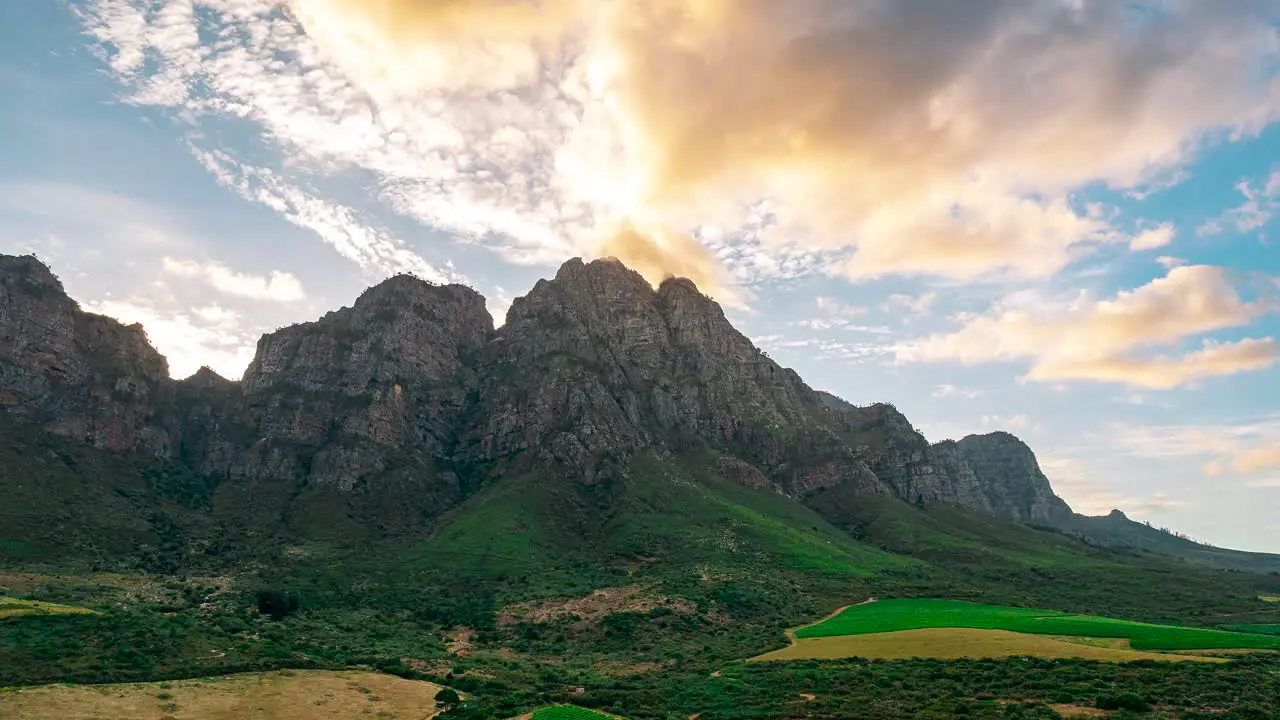 Immerse yourself in the serene charm of South Africa's mountains and lush green landscapes with this captivating hyperlapse showcasing the graceful dance of clouds against a backdrop of natural beauty