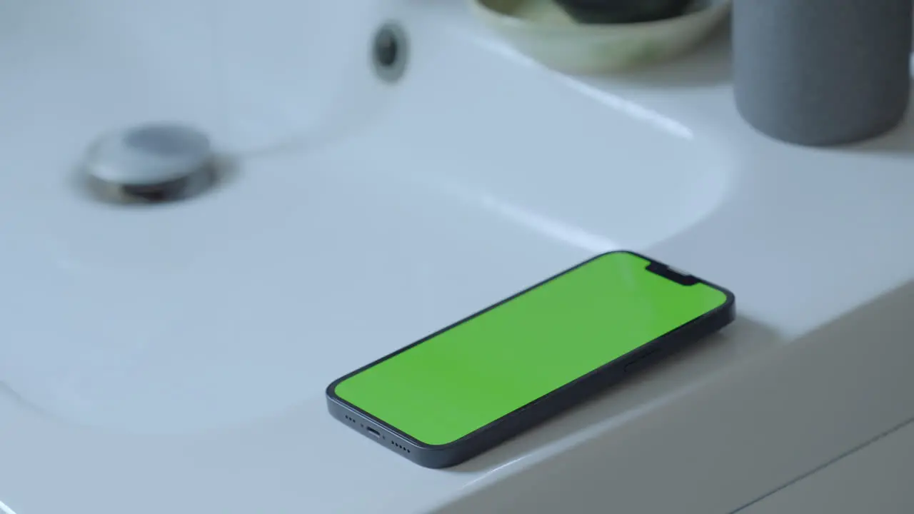 Creative Use iPhone 14 with Green Screen on Bathroom Sink Water Dripping from Tap Ambient Lighting Chroma Key