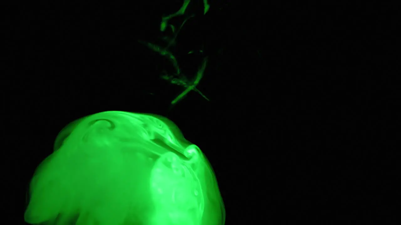 Slow Motion of Green Smoke Rising Illuminated in a Pitch Black Room