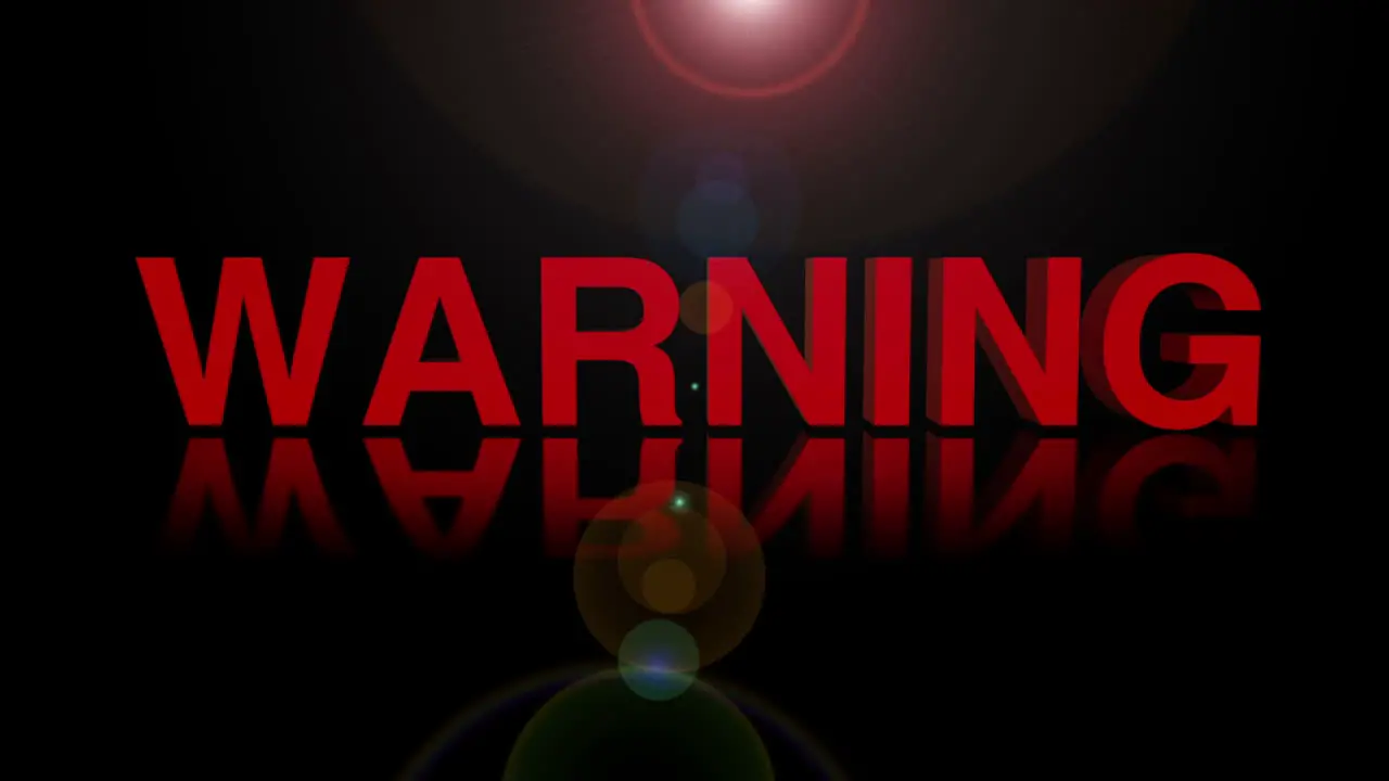 WARNING animation with moving lens flare against a black background