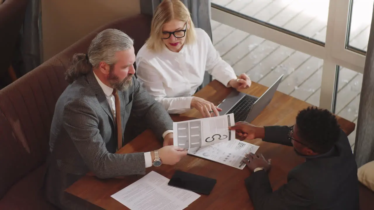 Multiethnic Mixed-Age Colleagues on Business Meeting in Restaurant