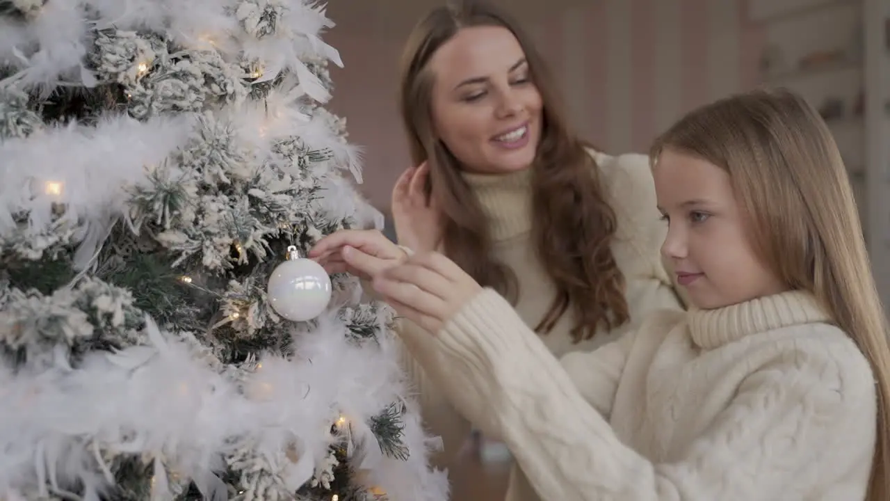 Mother And Daughter Decorate Christmas Tree With Balls And Ornaments