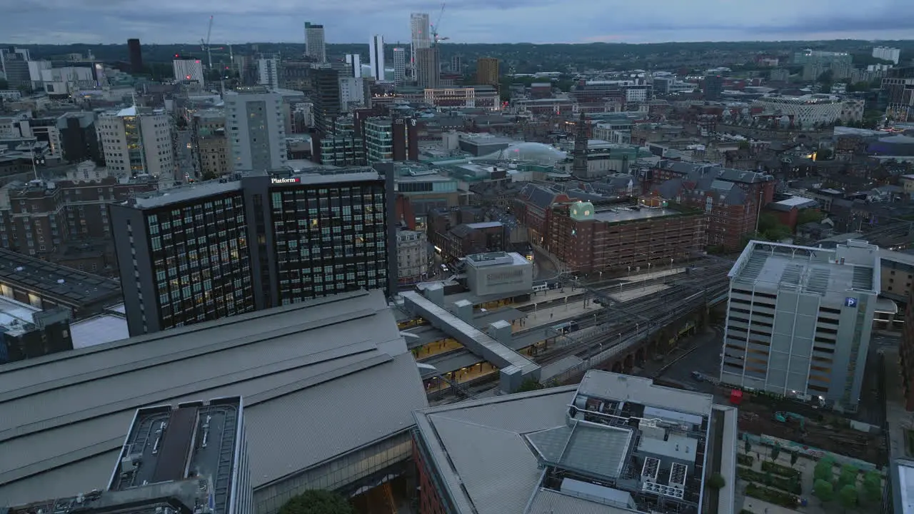 Establishing Drone Shot of Leeds Train Station with Leeds City Centre Skyline Behind in Low Light at Blue Hour West Yorkshire UK