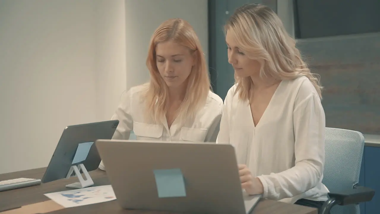 Pretty Young Blonde Women Having A Business Video Call And Showing Documents With Charts And Graphs