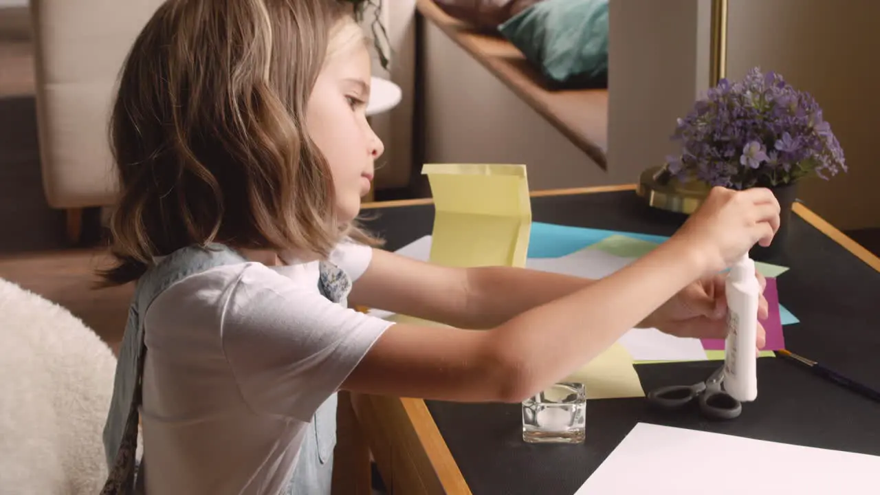 Blonde Girl Sitting At The Desk While Working With Cardboard