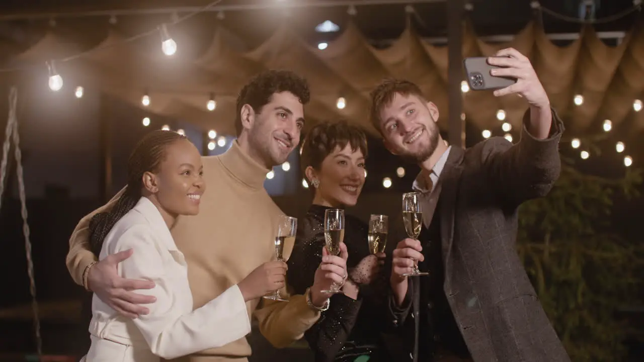 Group Of Four Happy Multiethnic Friends With Champagne Glasses Taking A Selfie Photo At New Year's Eve Party