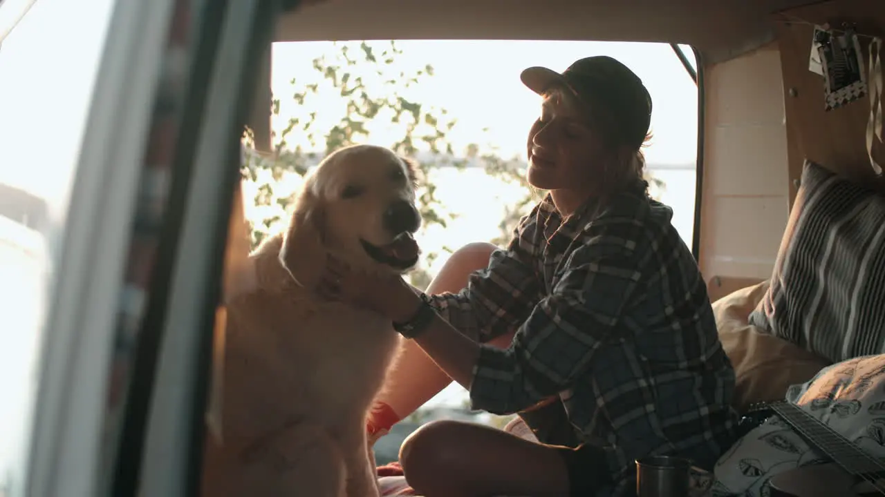 Woman Petting Dog in Travel Trailer at Lakeside