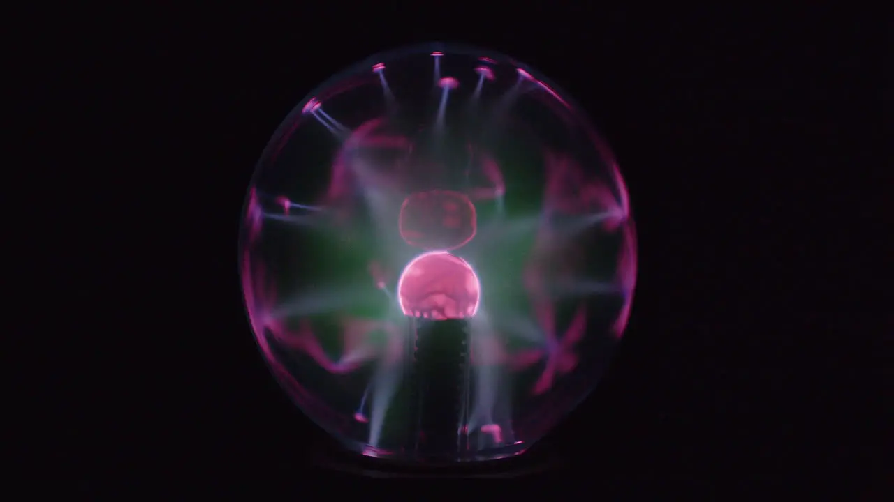 This is a close up video of a plasma globe running with a black background