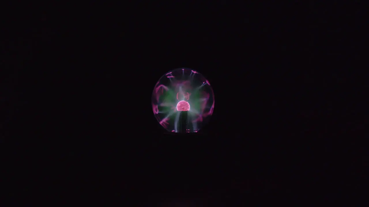 This is a far shot video of a plasma globe running with a black background