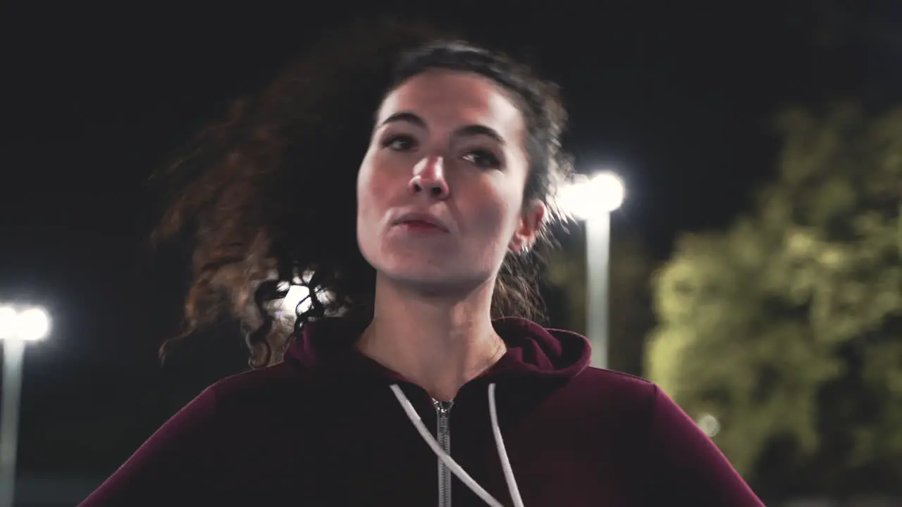 Portrait Of A Sportive Curly Girl Stretching Neck Before Training In The Park At Night 1