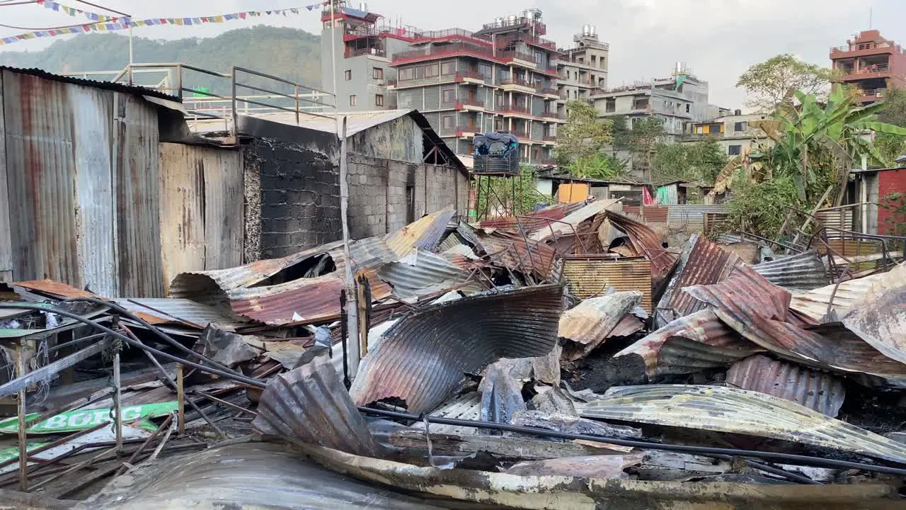 Twisted tin sheets and the ruined remains of a restaurant after a fire