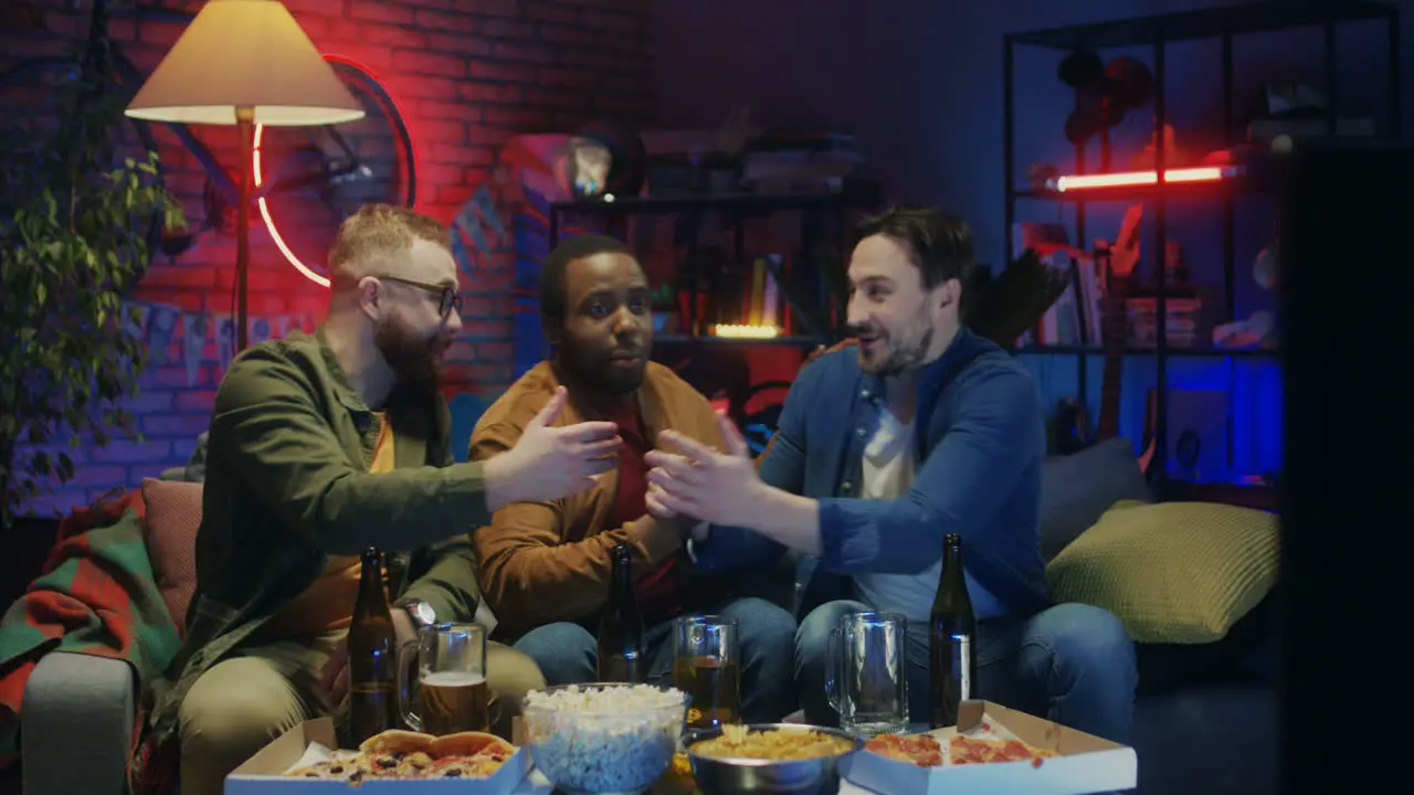 Mixed Races Male Young Happy Friends Watching Sport Game On Tv With Beer And Cheering Up For Their Team When Their Buddy Joining Them