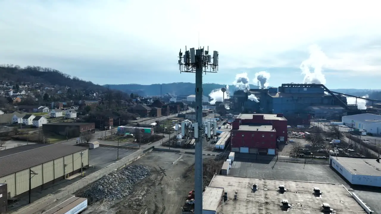 Aerial orbit around cell tower in rundown steel town in Pennsylvania