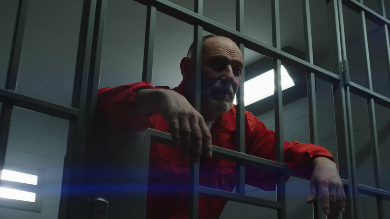 Angry Prison Officer Watches Criminals in Prison Cells     (Stock Footage)