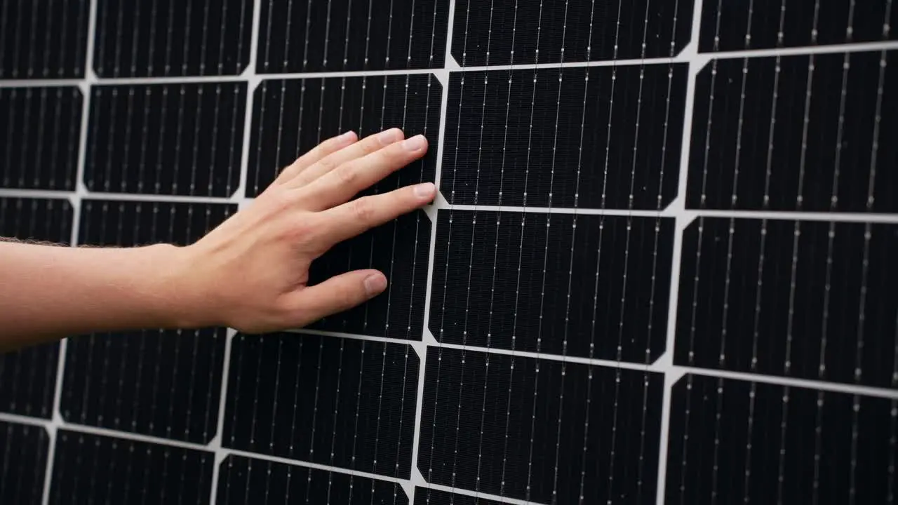 Hand inspecting efficient solar panel touching cells closeup static day