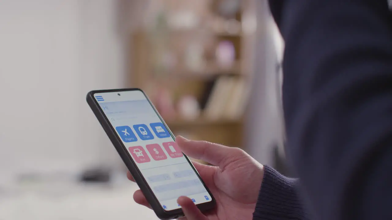 Close Up Of Person Leaving For Summer Holiday Checking Travel App On Mobile Phone Before Leaving Home