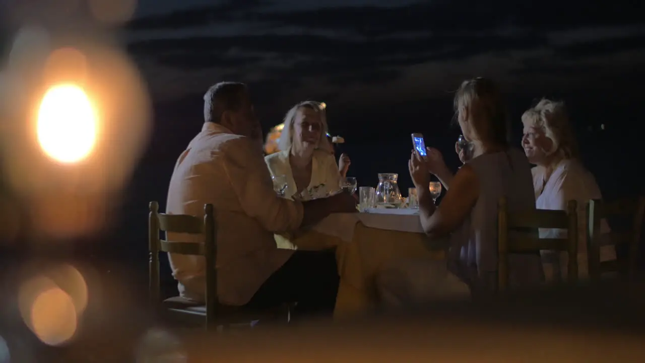 Family sitting at a table in evening in city Perea Greece