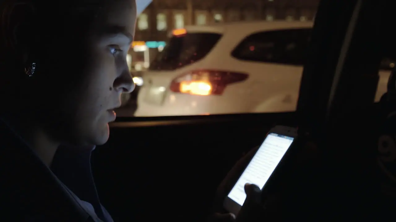 Young woman rides in the back seat of car