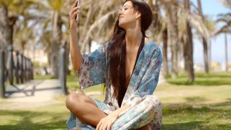 Pretty Girl Resting on Ground Talking Selfie