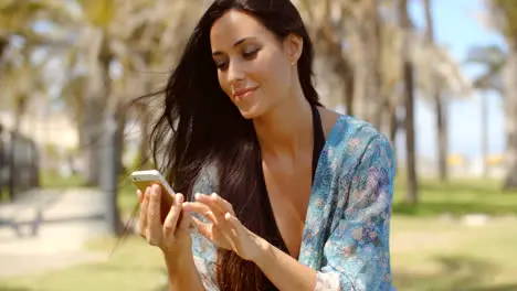 Pretty Lady in Beach Wear Using her Mobile Phone