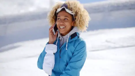 Happy adult in snowsuit with cell phone