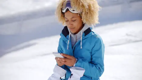 Woman in snowsuit checking phone