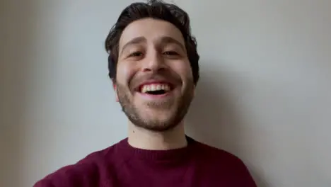 Young Male University Student Talking and Raising Glass Directly to Camera