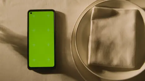 Overhead Of Table Setting With Plate And Green Screen Mobile Phone