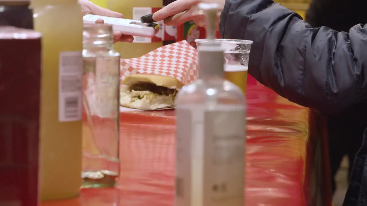 Person Making Contactless Payment Using Phone At Food Stall At Christmas Market