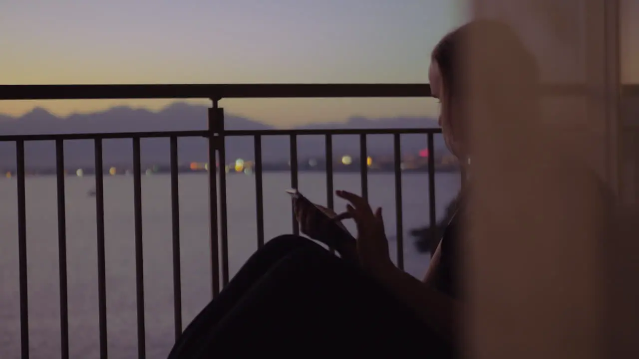 Young woman on a balcony against sea scenery