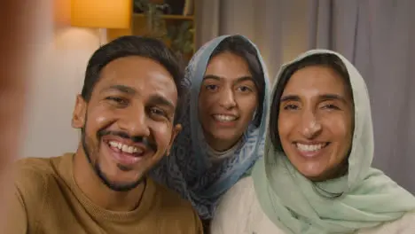 POV Shot Of Muslim Family Making Video Call Sitting Around Table At Home