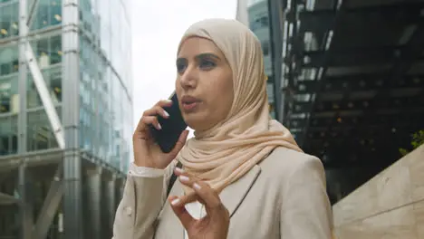 Muslim Businesswoman On Mobile Phone Standing Outside Office In City 6