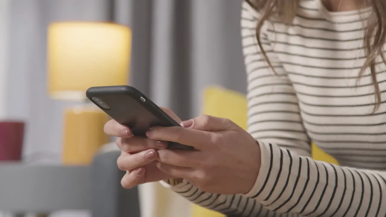 Close Up Of Woman At Home Shopping Online Using Mobile Phone 