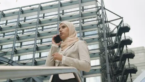 Muslim Businesswoman On Mobile Phone Standing Outside Office In City 1