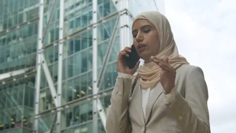 Muslim Businesswoman On Mobile Phone Standing Outside Office In City 4