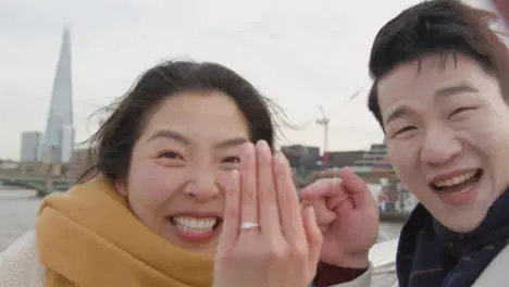 Young Asian Couple In London UK Making Video Call Home On Phone Announce Engagement To Family