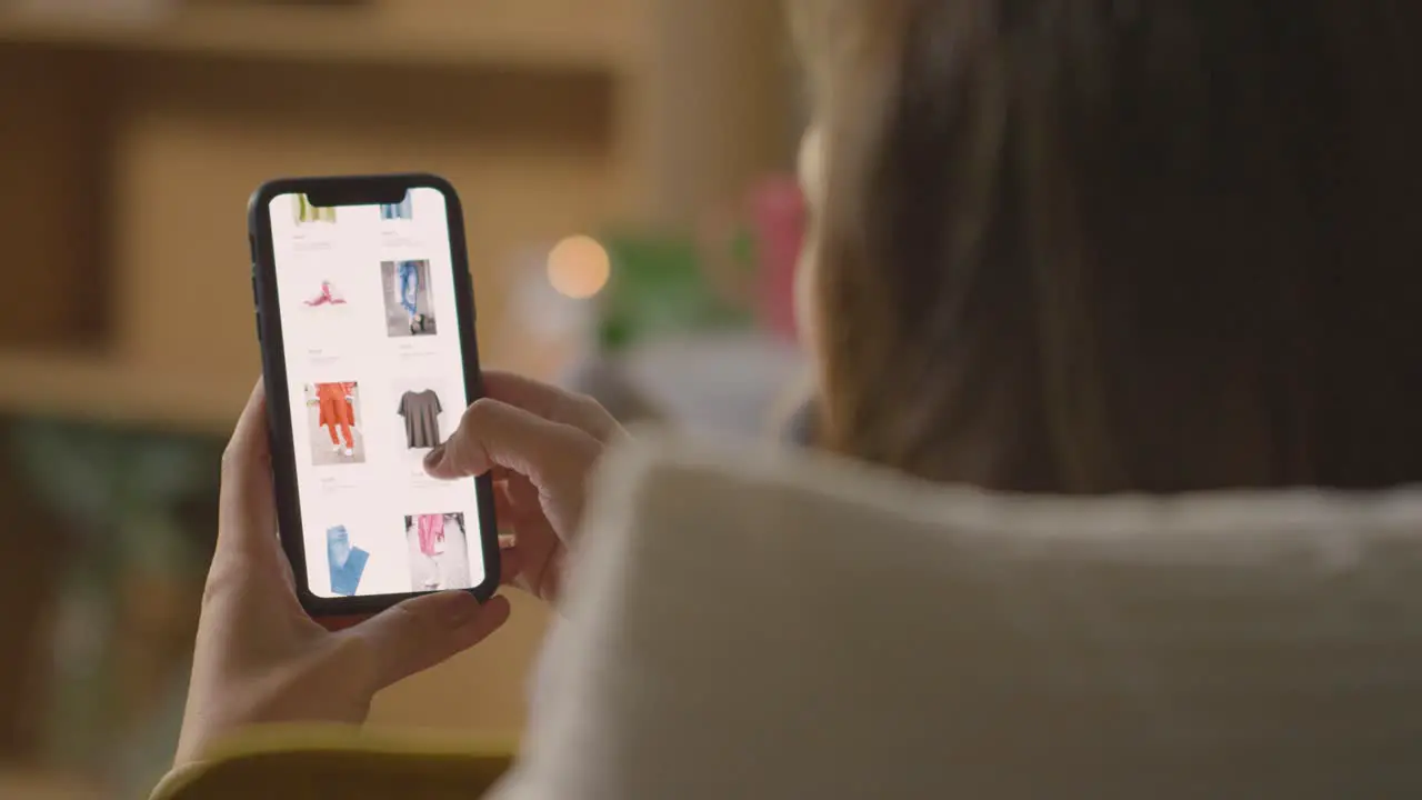 Close Up Of Woman At Home Shopping Online For Clothes Using Mobile Phone 4