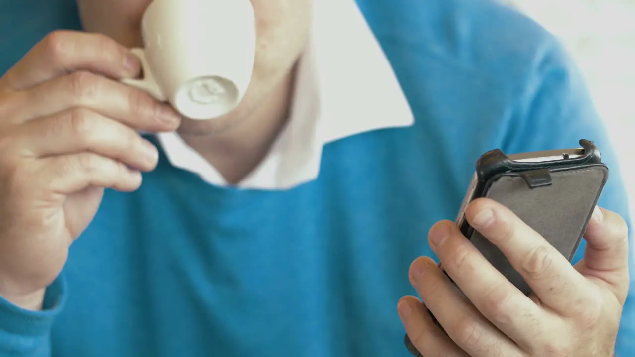 Adult Man Using Smartphone And Drinking Coffee