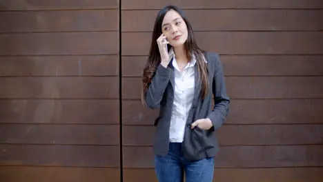 Casual relaxed young woman talking on a mobile