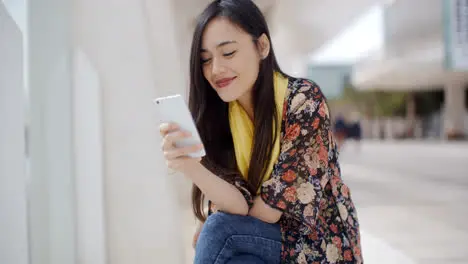 Chic young woman reading a mobile message