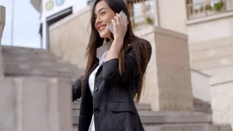 Happy young woman chatting on her mobile