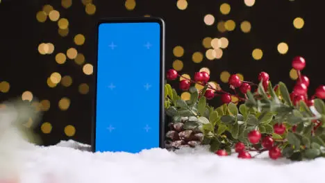 Blue Screen Mobile Phone On Christmas Background With Snow And Foliage 2