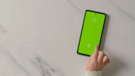 Overhead Studio Shot Of Child Using Green Screen Mobile Phone