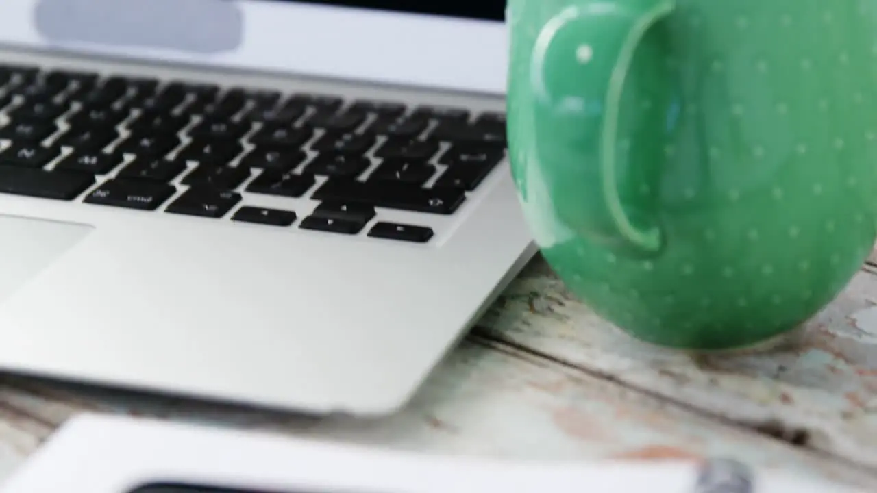 Coffee mug laptop mobile phone on wooden plank