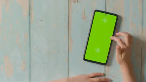 Overhead Studio Shot Of Child Using Green Screen Mobile Phone 1